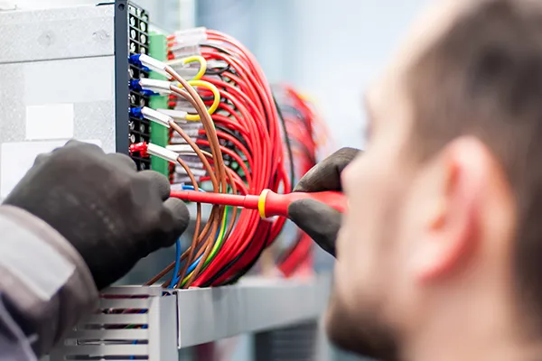 An image showing an electrician working on electronics